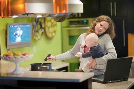 женщина с ребенком варит суп и смотрит сериал