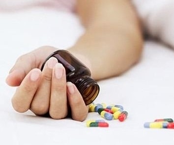 в руке бутылочка с таблетками