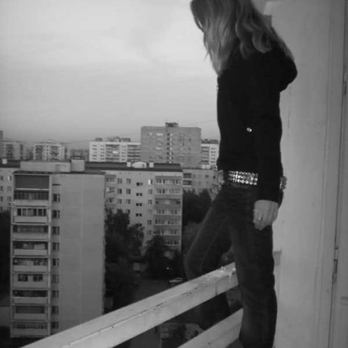 девушка стоит на краю подоконника