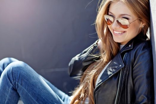 девушка в очках от солнца сидит и улыбается